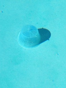 pool strainer basket with weights positioned over the main pool drain